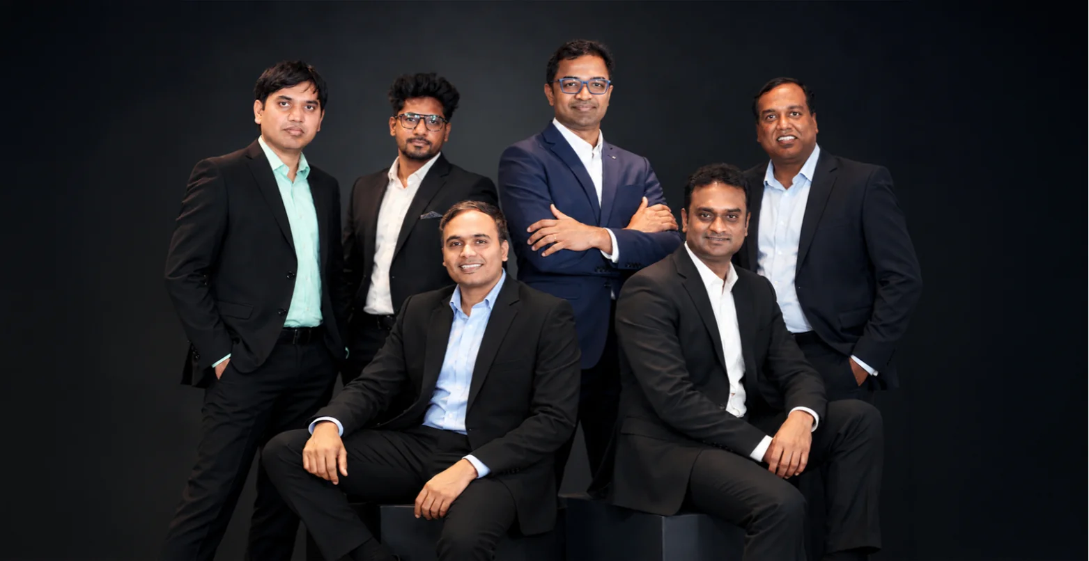 The EB1A Experts leadership team in business attire, standing together in the office